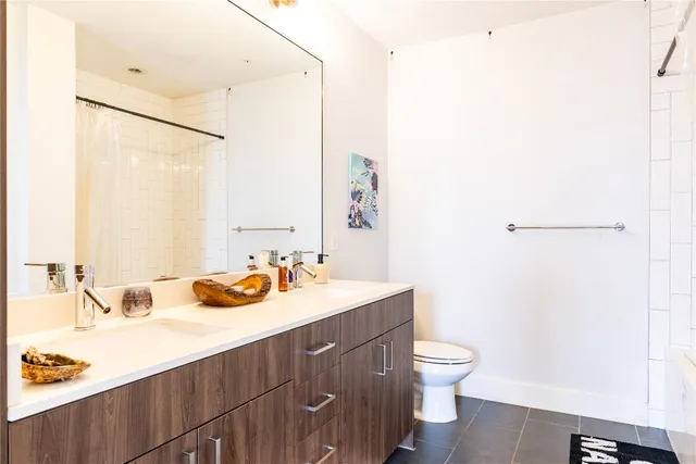 a bathroom with a sink a toilet and a mirror