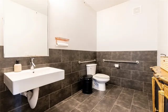 a bathroom with a sink a toilet and a mirror