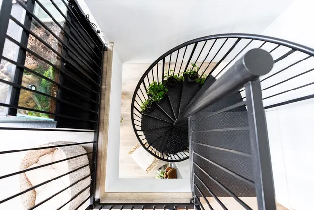 a view of staircase with railing and a potted plant
