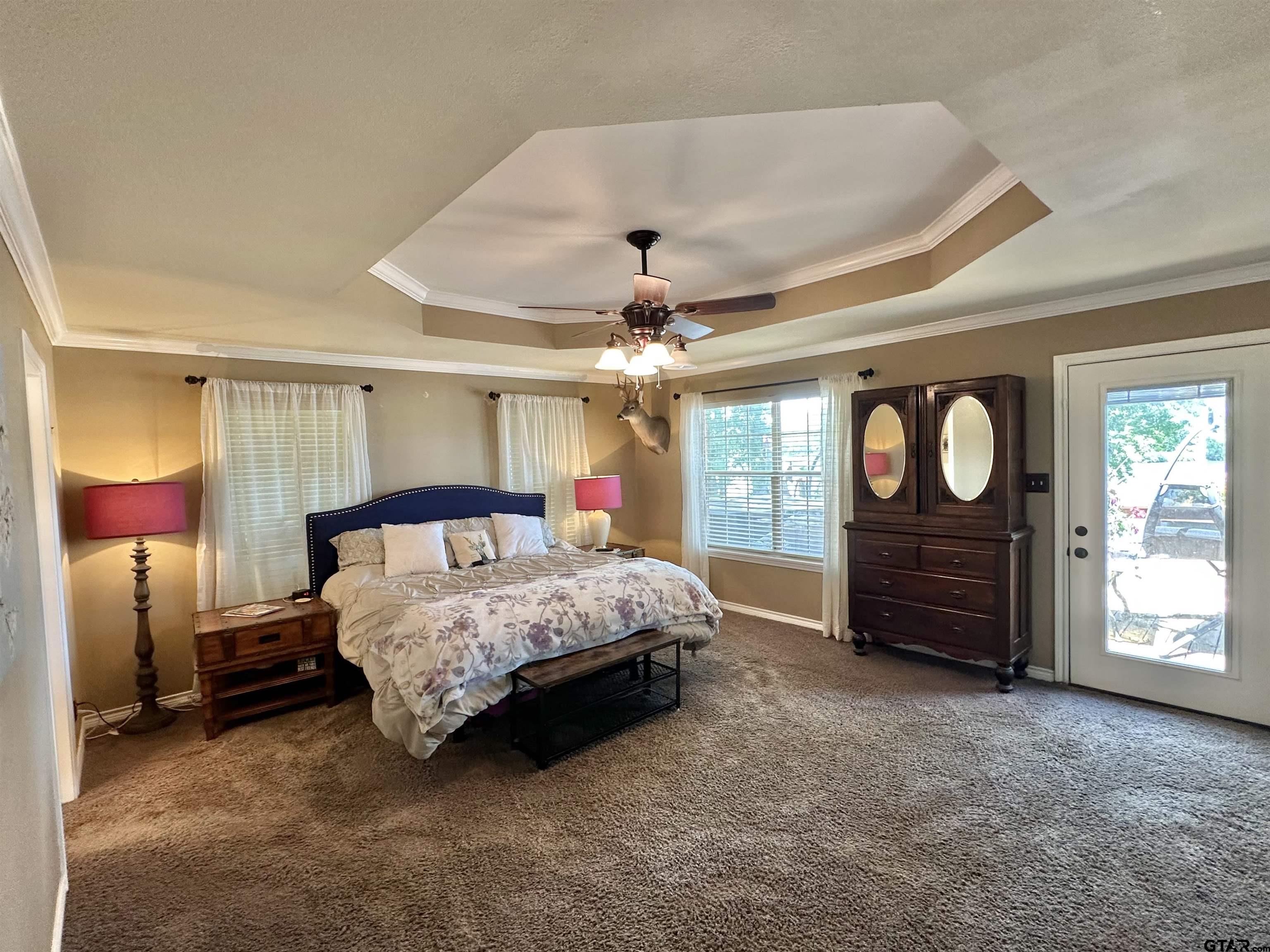 13449 South Hillcreek Road Whitehouse, TX 75791 - Photo 17 of 41 a spacious bedroom with a bed a dresser and a chandelier