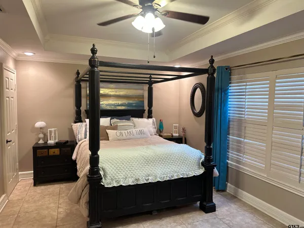 a bedroom with a bed mirror and window