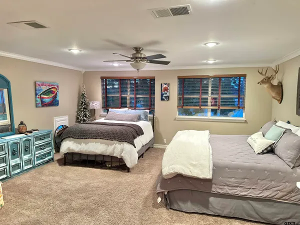 a spacious bedroom with a bed and glass walk in closet