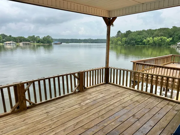 a balcony with wooden floor and lake view