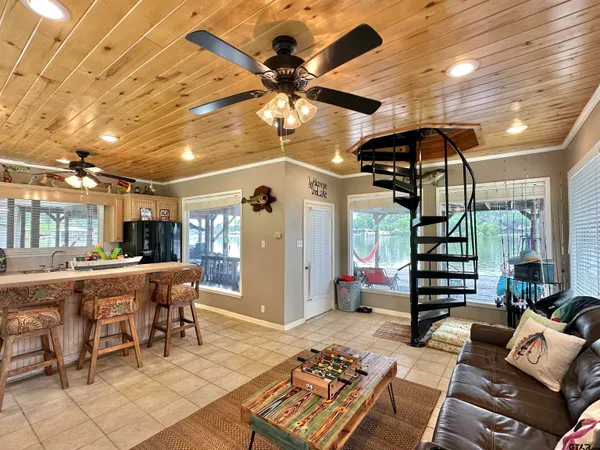 a living room with furniture a chandelier and a projector screen