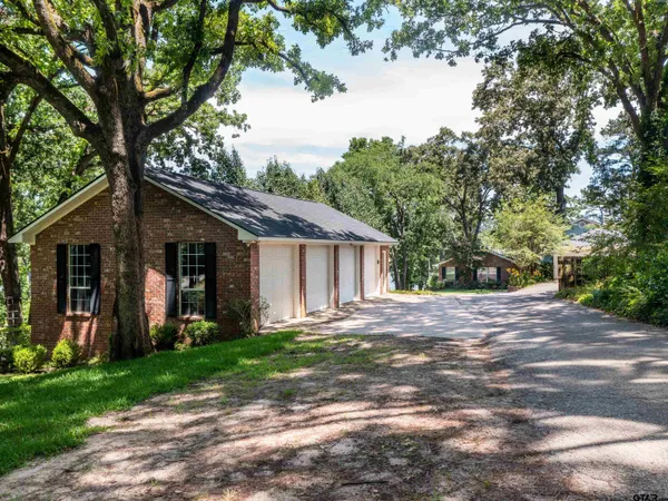 a view of a yard in front of a house with large tree