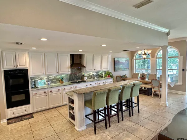 a kitchen with a sink and chairs