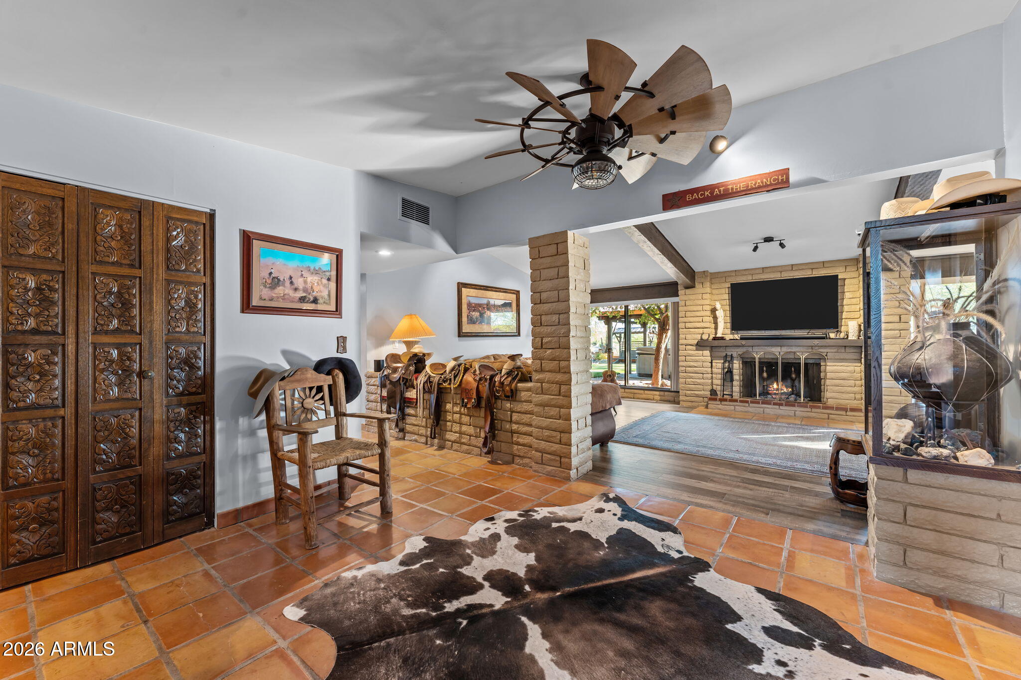 1349 North Forty Road Wickenburg, AZ 85390 - Photo 11 of 49 a living room with furniture a flat screen tv and a chandelier