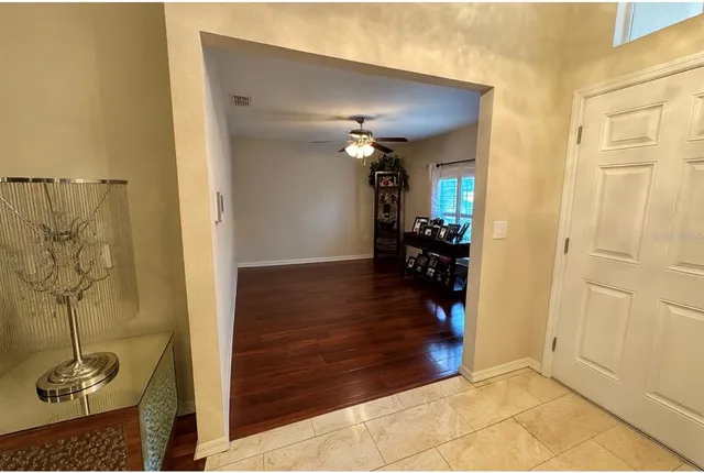 a view of a hallway with wooden floor and a livingroom view