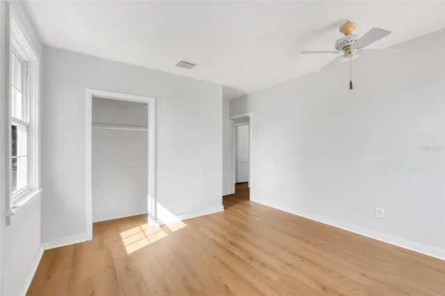 a view of room with hardwood floor and a ceiling fan