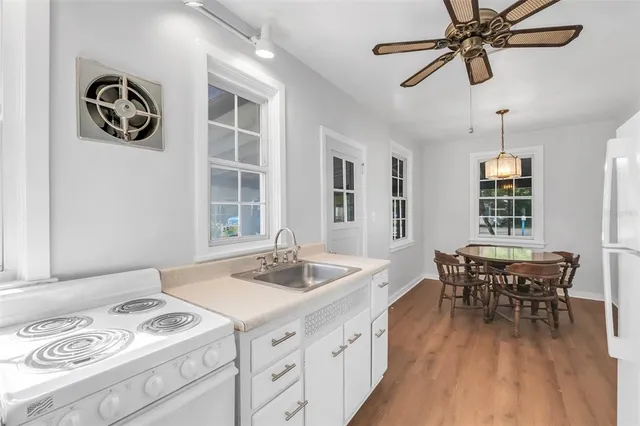 a kitchen with a table chairs cabinets and window