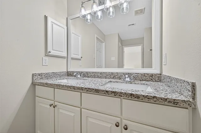a bathroom with a granite countertop sink and a mirror