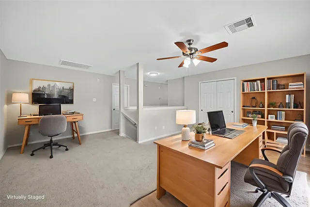 a view of a workspace with furniture and a window