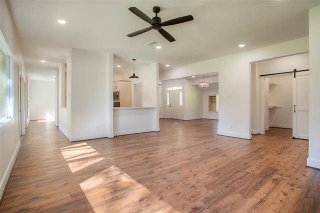 a view of a livingroom with a ceiling fan wooden floor and a ceiling fan