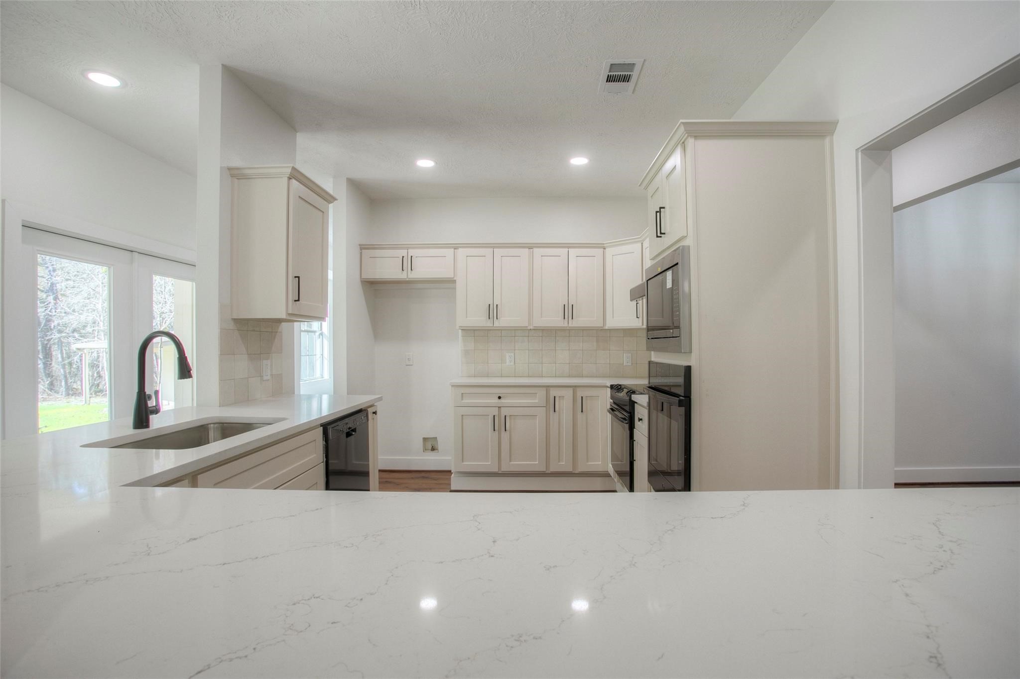 83 Dahlia Road Huntsville, TX 77320 - Photo 16 of 49 a kitchen with stainless steel appliances granite countertop a sink a stove and a refrigerator