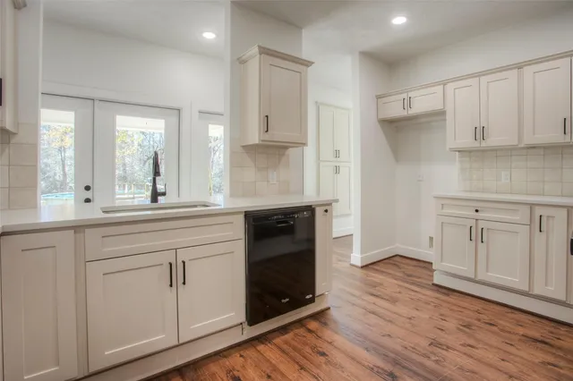 a kitchen with white cabinets and a wooden floors