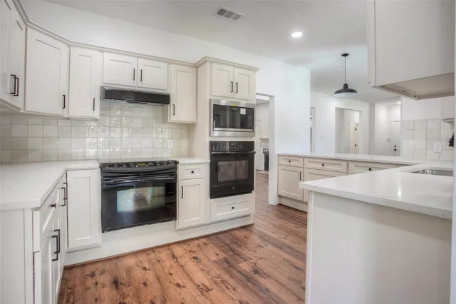 a kitchen with stainless steel appliances a stove a sink and a microwave