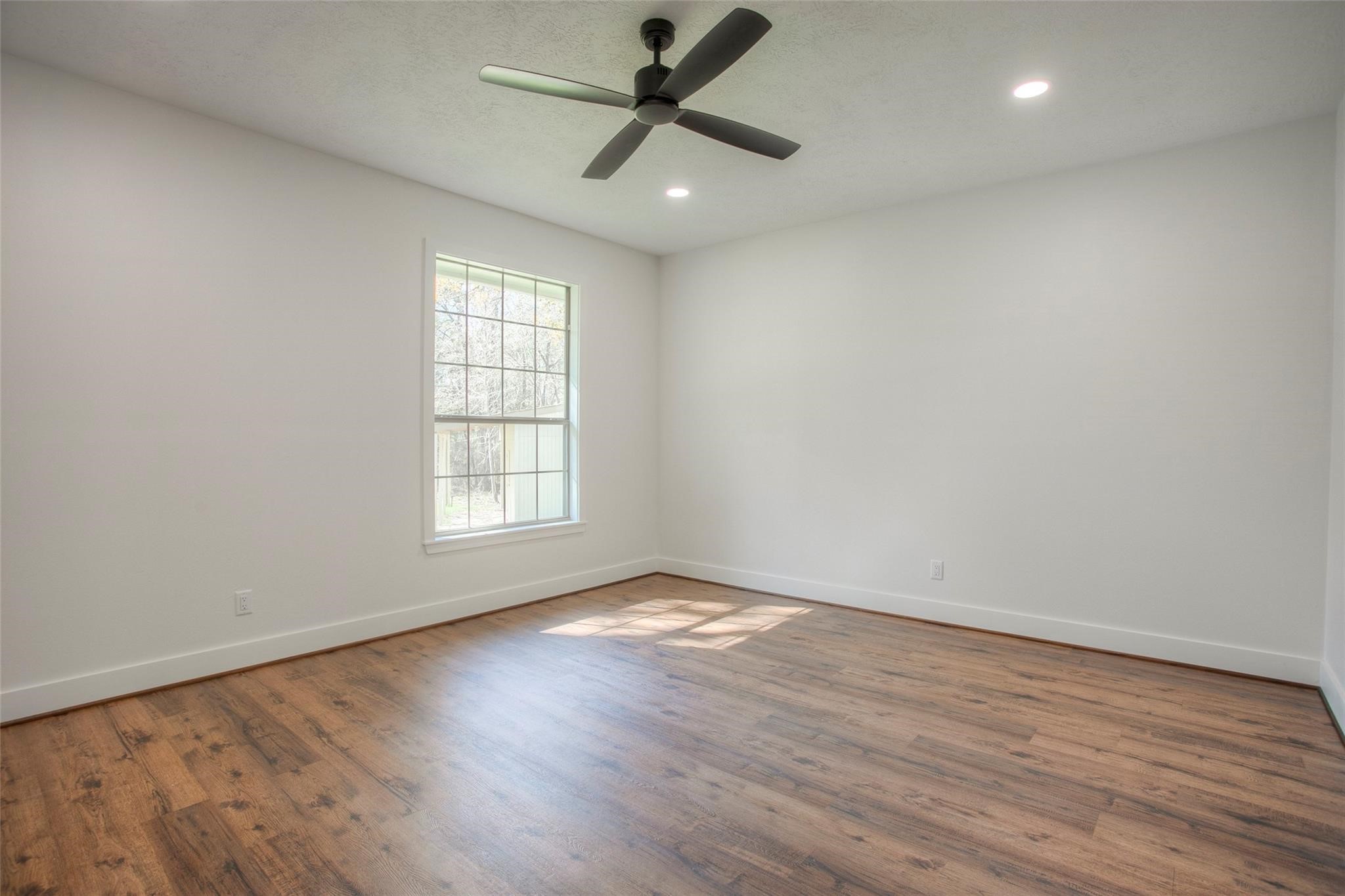 83 Dahlia Road Huntsville, TX 77320 - Photo 22 of 49 an empty room with wooden floor and windows