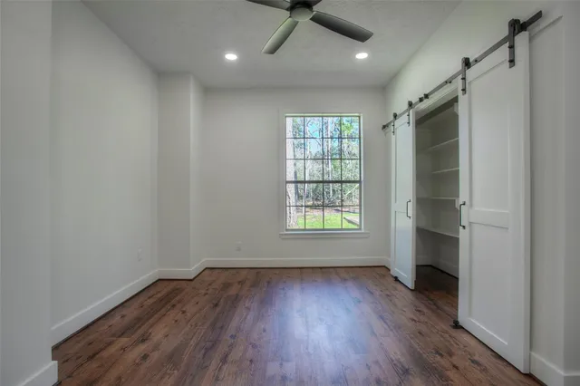 an empty room with wooden floor and a window