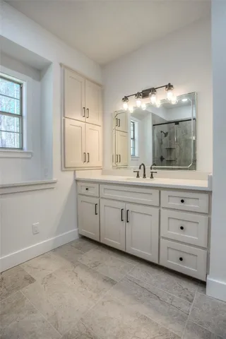 a spacious bathroom with a granite countertop sink and a mirror