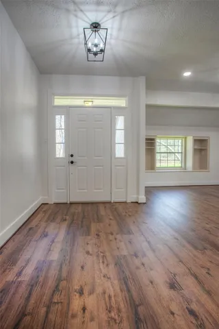 an empty room with wooden floor and window