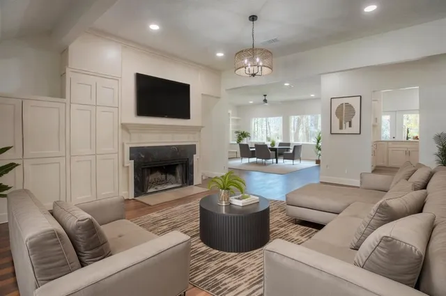 a living room with furniture a flat screen tv and a fireplace