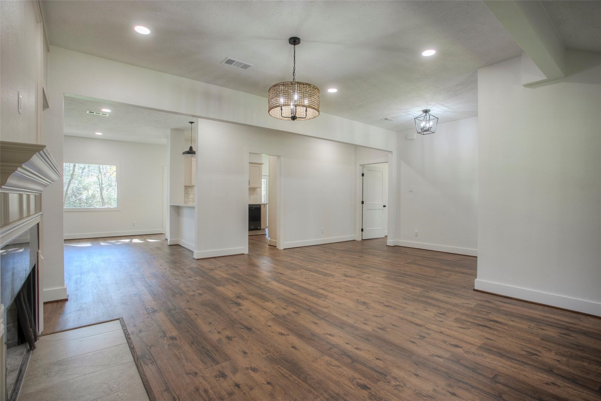 83 Dahlia Road Huntsville, TX 77320 - Photo 10 of 49 an empty room with wooden floor fireplace and windows