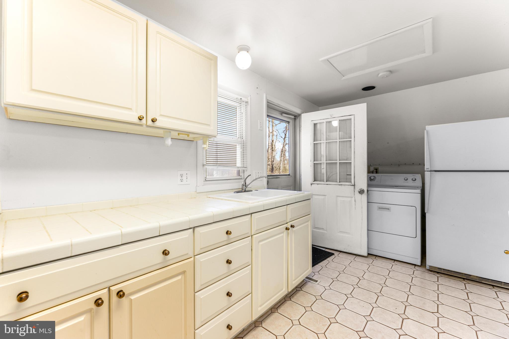 6204 Ebenezer Road Middle River, MD 21220 - Photo 49 of 70 a kitchen with white cabinets and white appliances