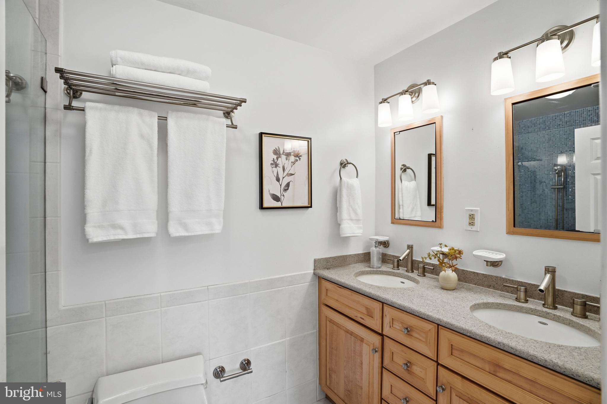 9614 Percussion Way Vienna, VA 22182 - Photo 22 of 45 a bathroom with a granite countertop sink a mirror and a shower