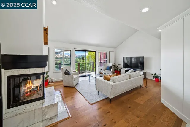 a living room with furniture a flat screen tv and a fireplace