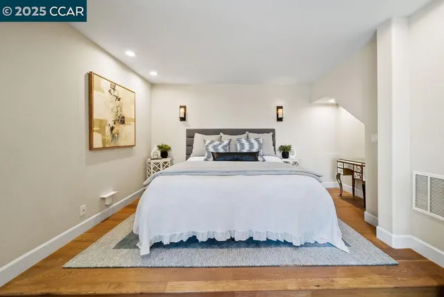 a bedroom with a bed and wooden floor