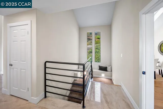 a view of a hallway with wooden floor and staircase