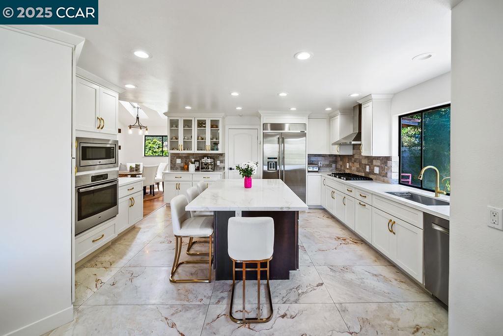 172 Rudgear Drive Walnut Creek, CA 94596 - Photo 9 of 51 a kitchen with stainless steel appliances kitchen island granite countertop a stove top oven a sink dishwasher and a refrigerator
