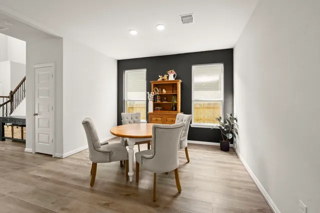a dining room with furniture and wooden floor