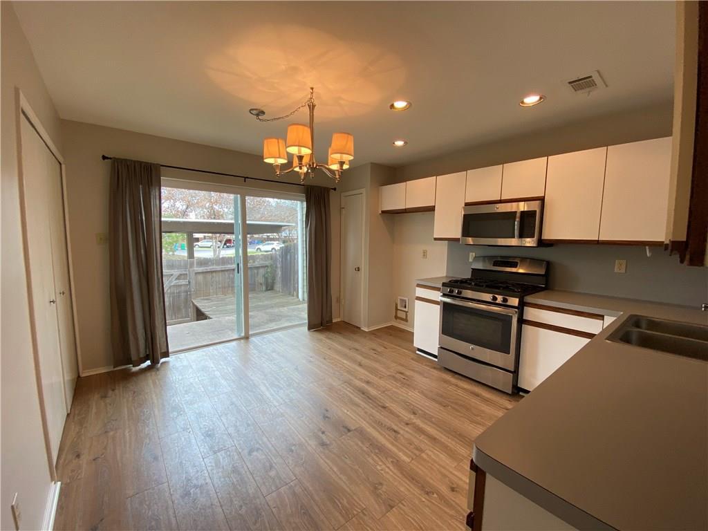 12325 Los Indios Trail, Unit 9 Austin, TX 78729 - Photo 11 of 30 Kitchen with appliances with stainless steel finishes, recessed lighting, light wood-style floors, a chandelier, and white cabinets