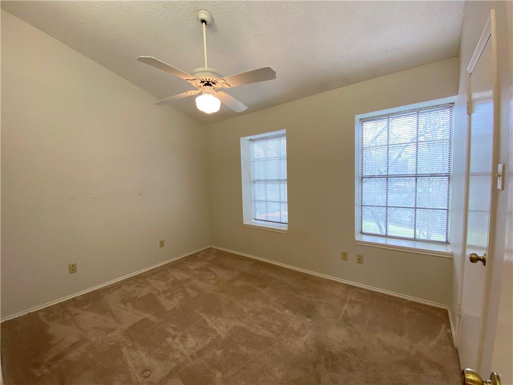 12325 Los Indios Trail, Unit 9 Austin, TX 78729 - Photo 18 of 30 Carpeted empty room with lofted ceiling, a textured ceiling, and ceiling fan