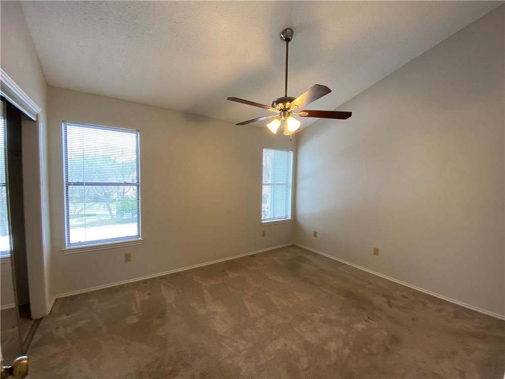 12325 Los Indios Trail, Unit 9 Austin, TX 78729 - Photo 20 of 30 Spare room with lofted ceiling, dark colored carpet, healthy amount of natural light, and ceiling fan