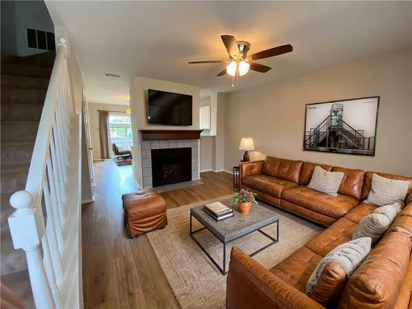 a living room with furniture a flat screen tv and a fireplace