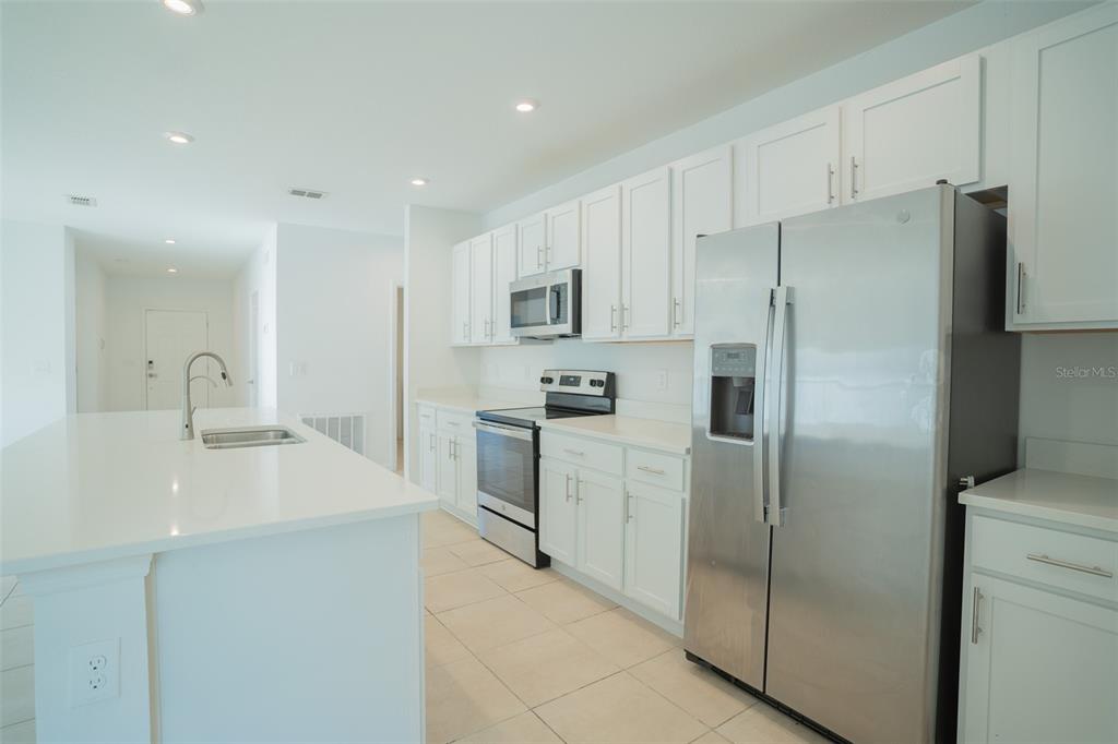 280 Citrine Loop Kissimmee, FL 34758 - Photo 4 of 25 a kitchen with stainless steel appliances a refrigerator sink and microwave