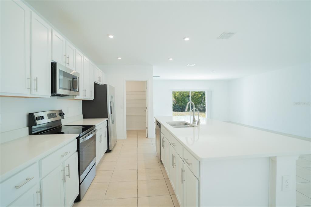 280 Citrine Loop Kissimmee, FL 34758 - Photo 5 of 25 a kitchen with stainless steel appliances a sink stove and cabinets