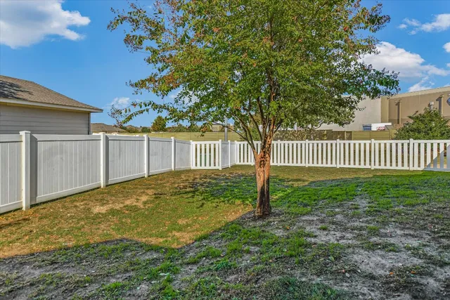 a view of a yard with wooden fence