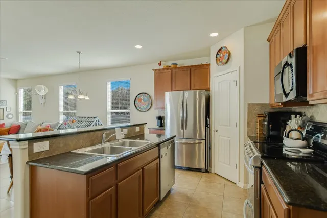 a kitchen with stainless steel appliances granite countertop a sink stove and refrigerator