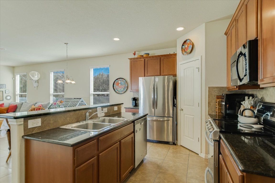 1700 Zilker Drive Cedar Park, TX 78613 - Photo 6 of 19 a kitchen with stainless steel appliances granite countertop a sink stove and refrigerator