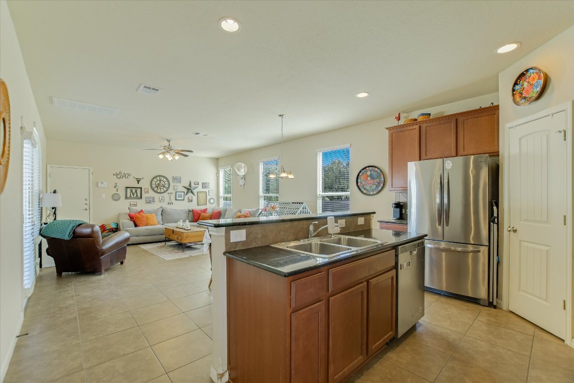 1700 Zilker Drive Cedar Park, TX 78613 - Photo 7 of 19 a kitchen with stainless steel appliances granite countertop a sink refrigerator and cabinets