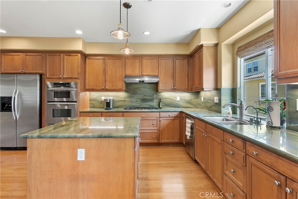 21331 Veleta Circle Huntington Beach, CA 92648 - Photo 5 of 14 a large kitchen with granite countertop a large counter top stainless steel appliances and cabinets
