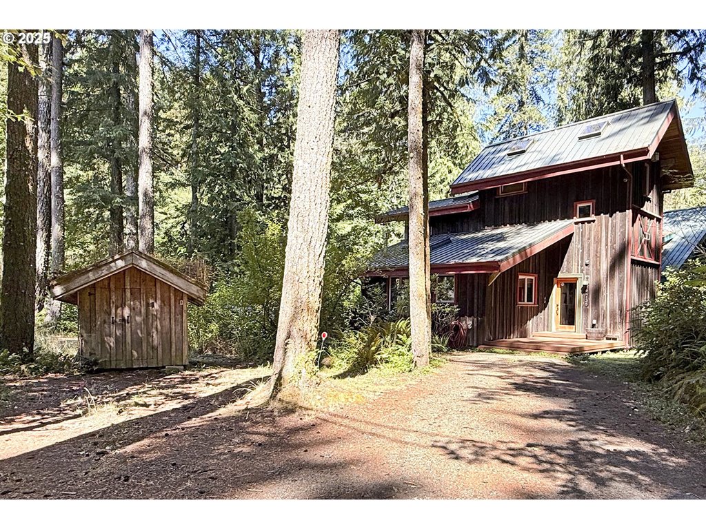 64135 East Relton Road Rhododendron, OR 97049 - Photo 1 of 48 a view of a wooden house with a large tree