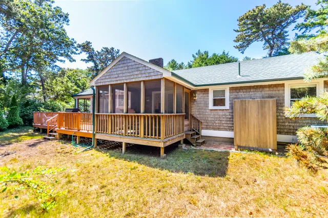 a view of a house with a wooden deck and a yard