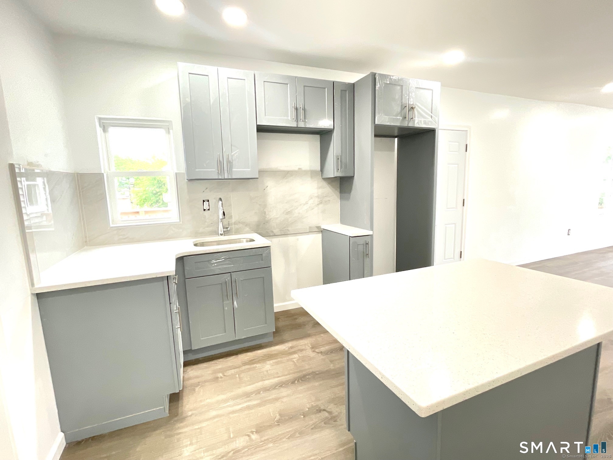 32 Lester Street, Unit 2 Ansonia, CT 06401 - Photo 7 of 9 a kitchen with a sink a stove a refrigerator and white cabinets