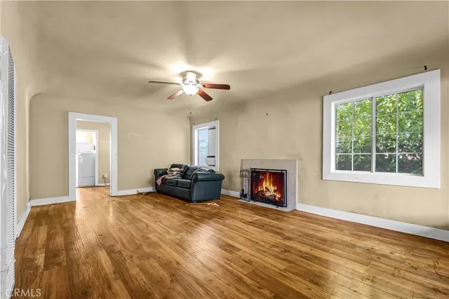 a view of a livingroom with a fireplace a chandelier and windows