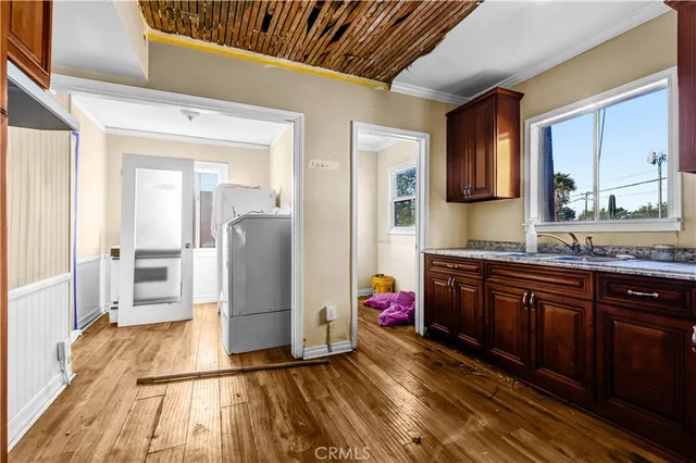 a kitchen with granite countertop a sink cabinets and stainless steel appliances