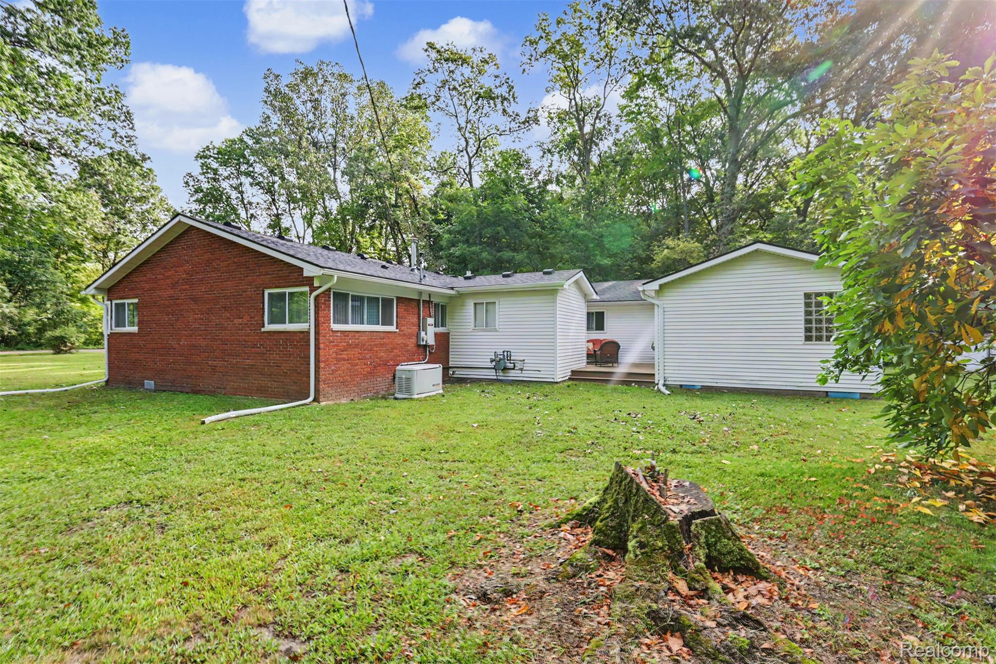 45223 Wear Road Belleville, MI 48111 - Photo 53 of 60 Expansive grassy yard with mature trees and a multi-textured exterior featuring brick and siding